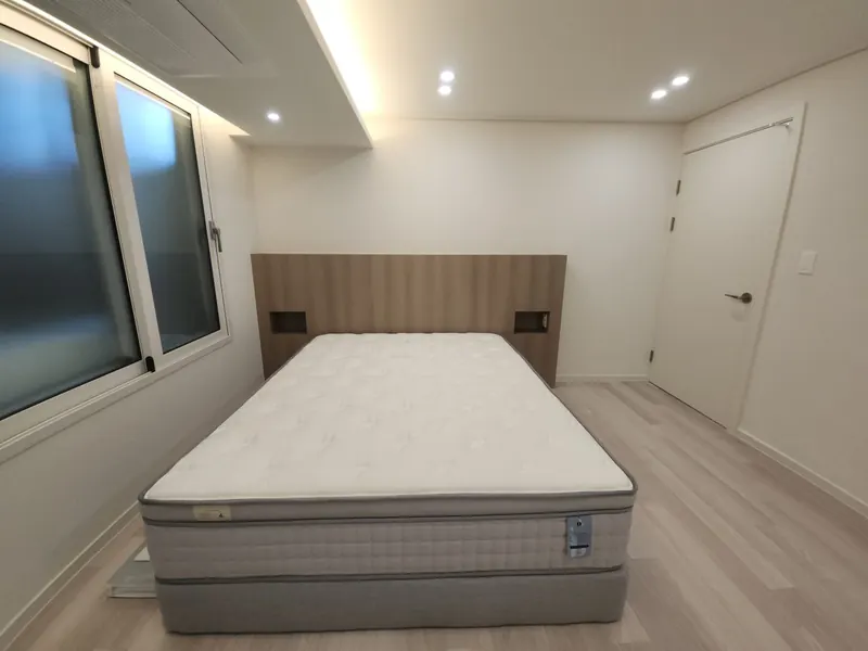 원목 헤드월과 간접조명으로 꾸민 아파트 안방