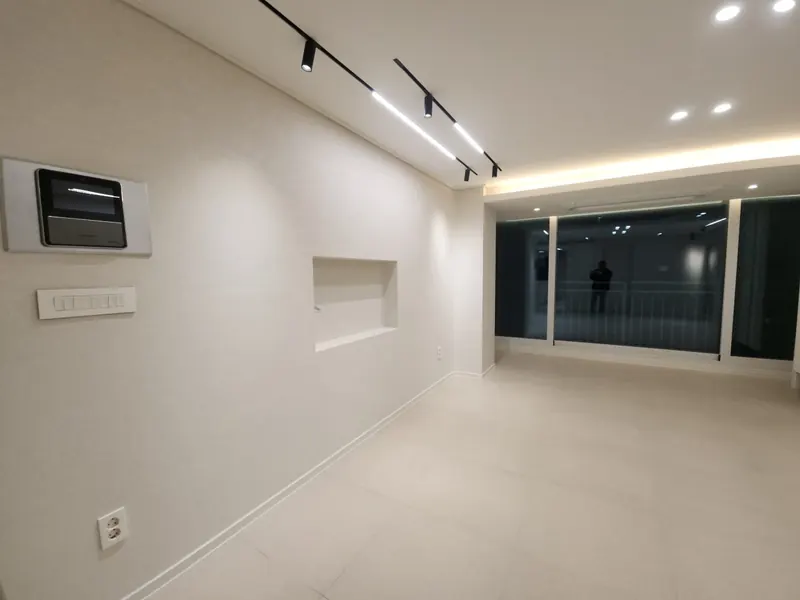 벽 매립 수납과 간접조명이 있는 아파트 거실 창가